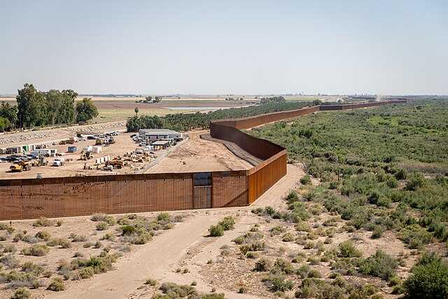 commons.wikimedia.org featured image Long fence stretching through arid landscape with vegetation