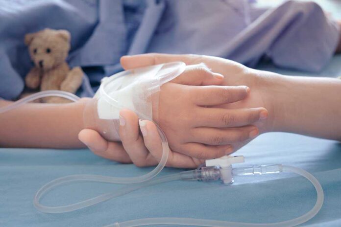 1168304533 featured image Childs hand with IV held by adult