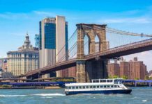 Boat passing under Brooklyn Bridge in New York.