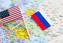 US and Russian flags on a world map