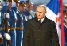 A man in dark coat at a military event