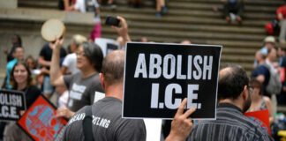 Protesters holding abolish ICE signs at demonstration