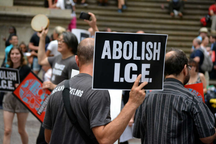 1148121836 featured image Protesters holding abolish ICE signs at demonstration