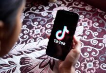 Hand holding phone showing TikTok logo