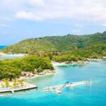 Tropical beach with docks and lush green hills