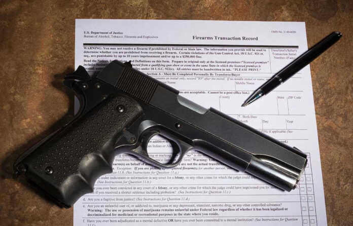 Gun and pen on firearm transaction form