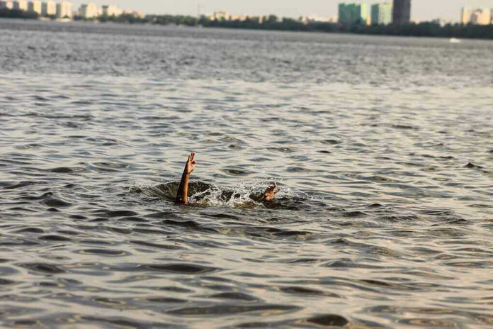 Person's hand reaching out from the water