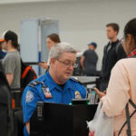 TSA agent checks passenger's documents at airport security
