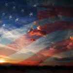 A sunset with an overlay of the American flag and dramatic clouds