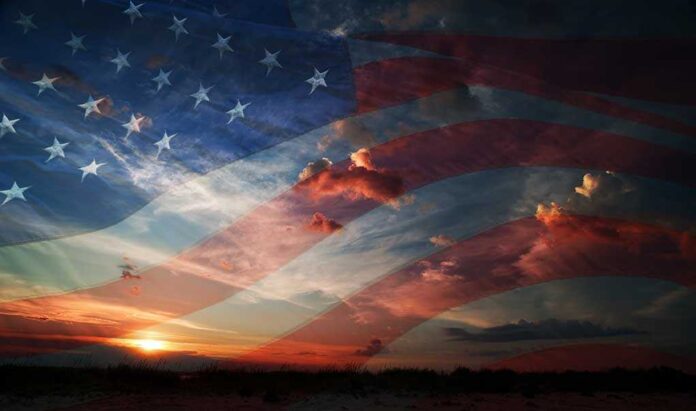 A sunset with an overlay of the American flag and dramatic clouds