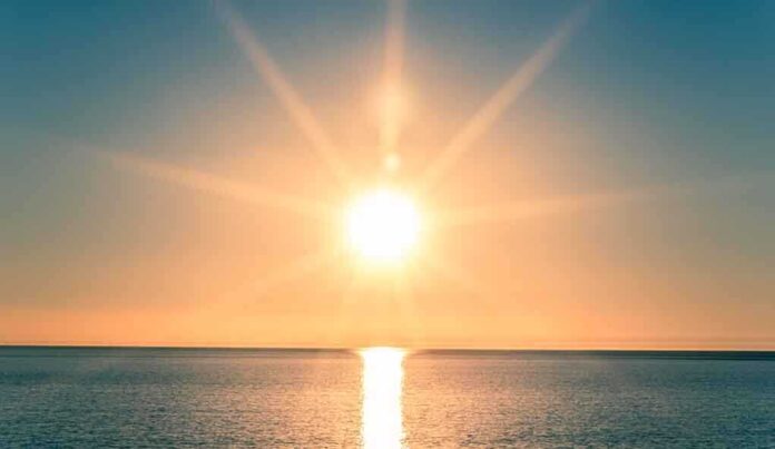 A serene sunrise over a calm ocean with vibrant colors in the sky