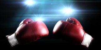 Two red boxing gloves facing each other with dramatic lighting