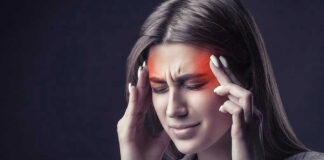 Woman holding head, experiencing intense headache or migraine.