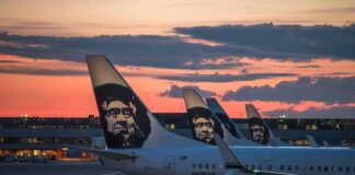 Aircraft tails with a sunset backdrop at an airport