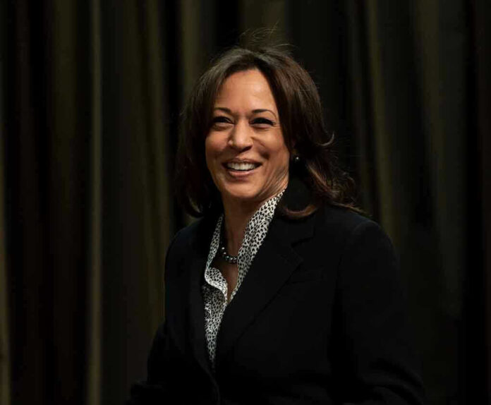Smiling woman in a suit, dark background.