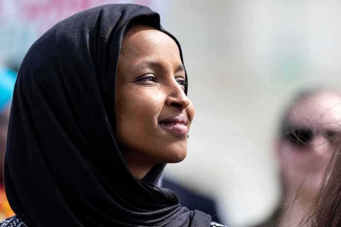 Woman wearing a black hijab looking thoughtfully into the distance