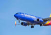 Airline Quietly Issues Major Carry-On Ban Southwest Airlines plane flying in blue sky.