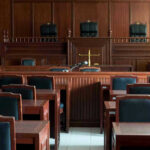 Empty courtroom with wooden furnishings and judges bench.