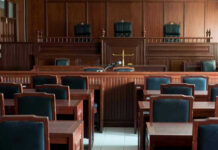 Empty courtroom with wooden furnishings and judges bench.
