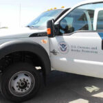 U.S. Customs and Border Protection truck with open door.