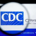 CDC Issues Travel Ban As WHO Declares Health Emergency! CDC logo magnified on a screen.