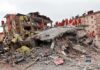 Shocking School Dorm Attack – Teens Caught in Wartime Crossfire Rescue workers in orange uniforms on a collapsed building site after an earthquake