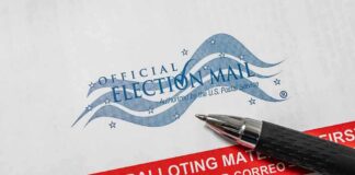 Official election mail envelope with a pen beside it