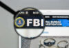 FBI Catches MOST WANTED Fraudster! FBI website shown through magnifying glass.