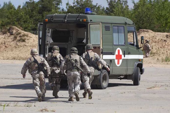 shutterstock_105071369 Soldiers running towards a medical vehicle during a military operation