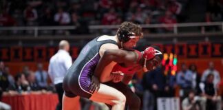 Two wrestlers competing on a mat during a match