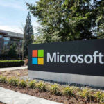 Microsoft ENDS U.S Jobs in Favor Of Foreigners! Microsoft sign with office buildings and trees.