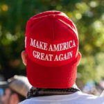 Boardwalk Brawl ERUPTS Over Trump Merch! Person wearing a red Make America Great Again hat.