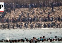 Thousands of migrants swim around the border from Morocco into Ceuta, Spain