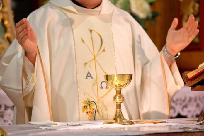 Priest,Celebrate,Mass,At,The,Church,And,Empty,Place,For A priest holding a golden chalice during a religious ceremony