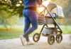 Person pushing a baby stroller on a park path