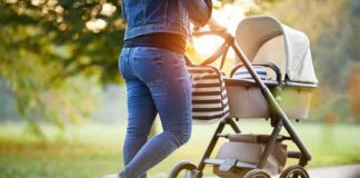 Person pushing a baby stroller on a park path