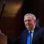Missing Senators Wife SPOTTED – Fuels Mystery A political figure smiling while holding a microphone