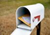 Suspect ARRESTED For Stealing Ballots Out of Mailboxes White mailbox with red flag holding envelopes and padded mailers