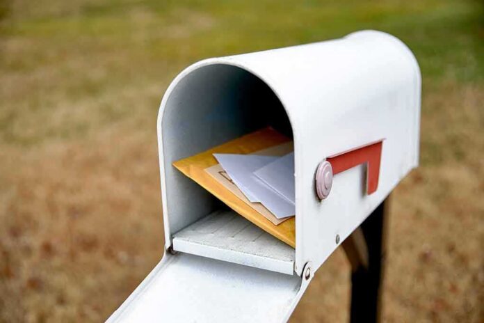 White mailbox with red flag holding envelopes and padded mailers