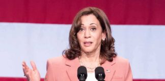 woman speaking at a podium with microphones