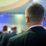 Iran Plan To Assassinate Trump LEAKED – Insane Plot! Man with earpiece at a crowded event.