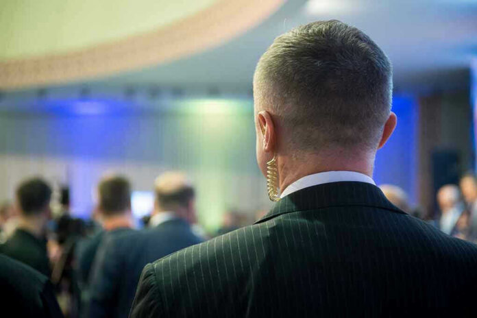1415251952 Man with earpiece at a crowded event.