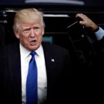 Donald Trump stepping out of a vehicle in a suit and blue tie