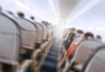 Airplane Cabin MAYHEM, Roof Collapses Mid-Flight Airplane cabin aisle with blurred passengers and seats