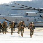 Embassy Alert Sparks Urgent Evacuation Plan Soldiers disembark and walk past a large military helicopter