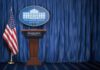Liberal Media Get Trump Back After Ban White House press briefing podium with U.S. flag and blue curtain