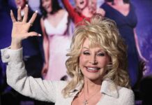 blonde woman waving at a red carpet event