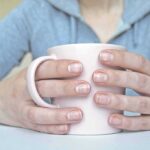 Hands holding a light pink mug