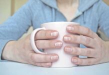 Hands holding a light pink mug