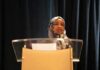 Woman in hijab speaking at a podium